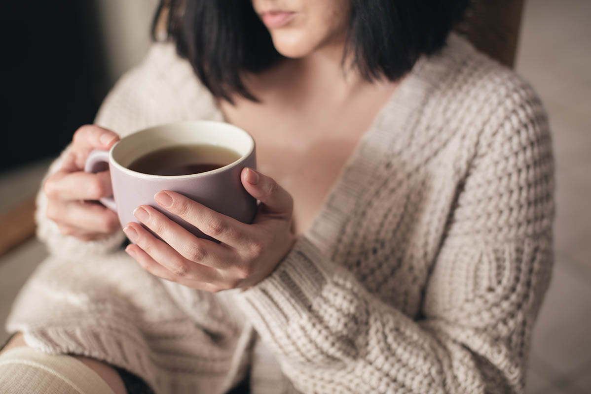 woman with invisalign aligners drinking tea