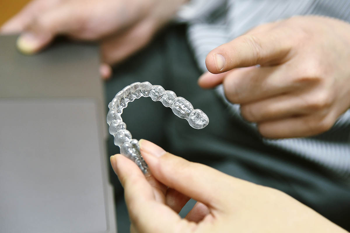 man holding invisalign aligners