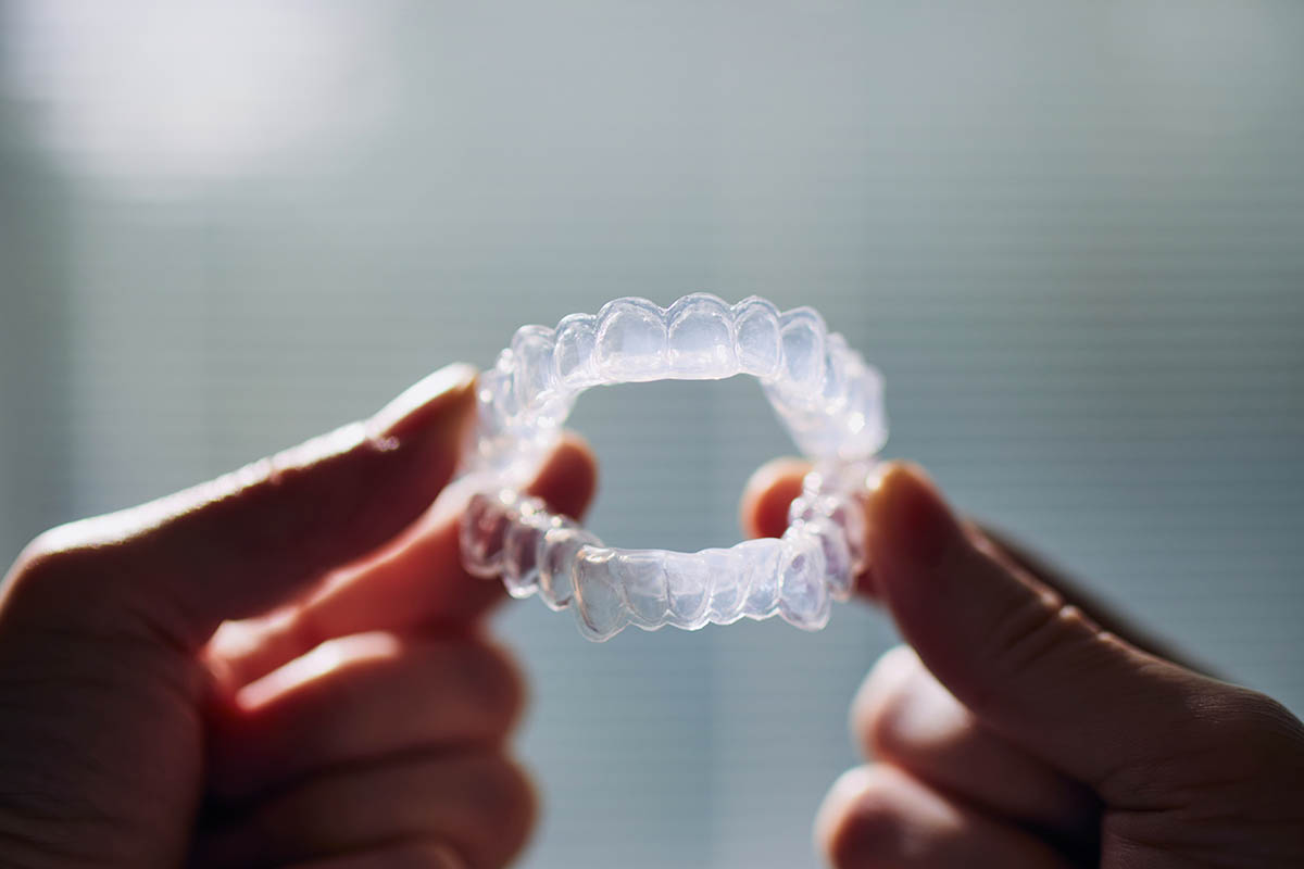 man holding invisalign aligners