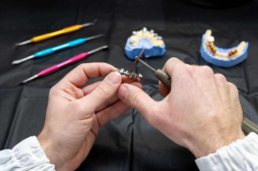dental technician working on dental dentures dental technician working on dental dentures