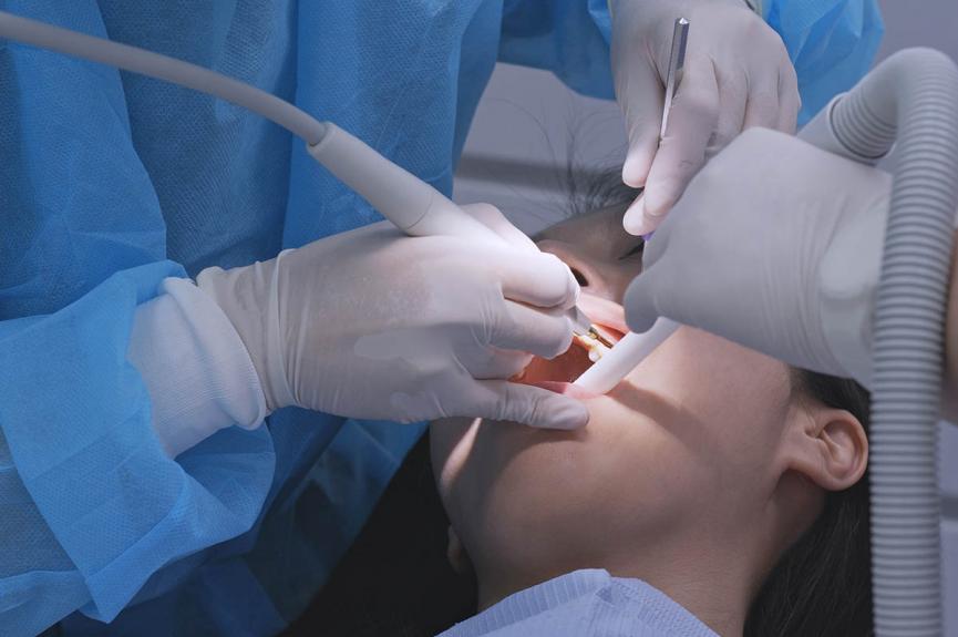 dentist examining woman for gingivitis dentist examining woman for gingivitis