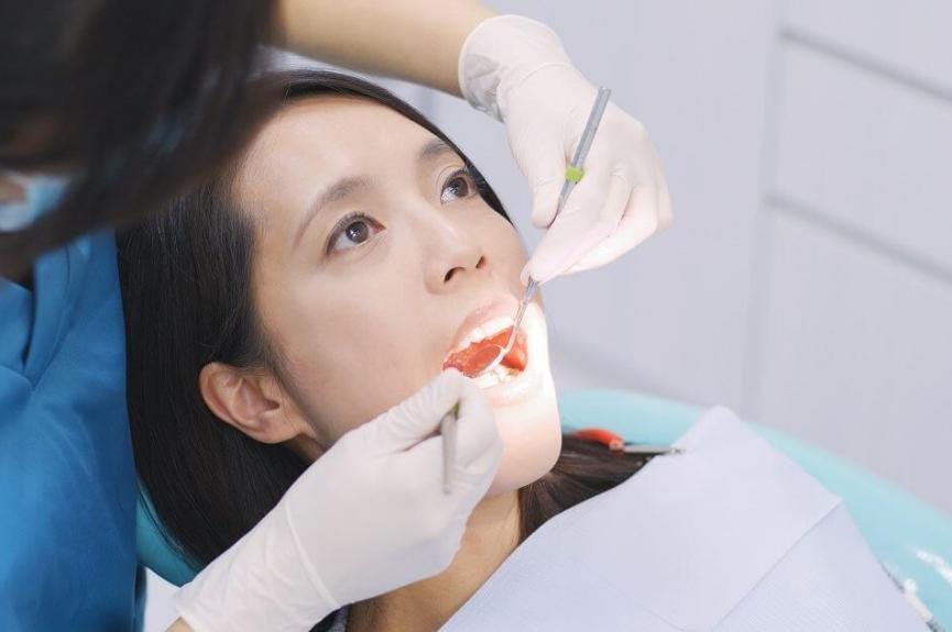 dentists examining a woman's gum health dentists examining a woman's gum health