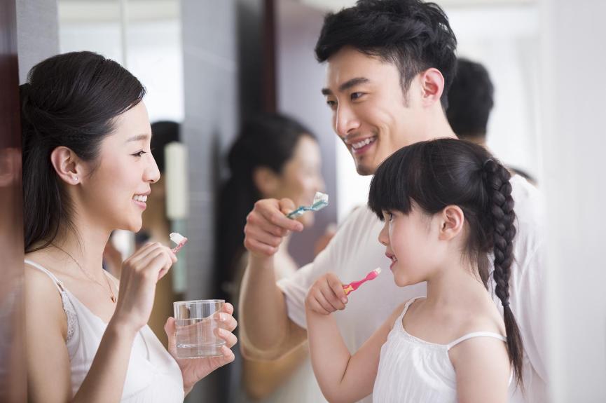 happy family brushing teeth in the bathroom