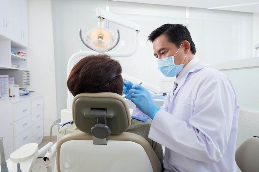 male dentist treating patient with tooth decay Singapore male dentist treating patient with tooth decay Singapore