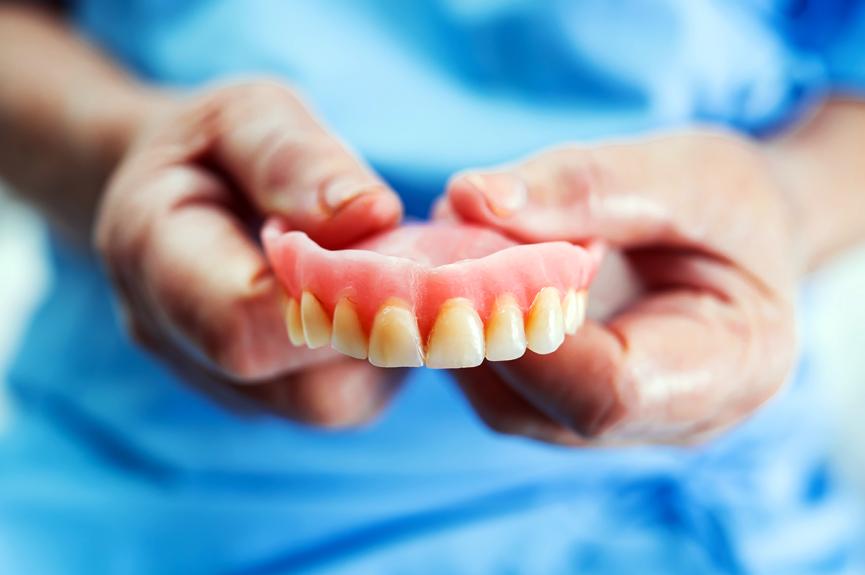 woman holding overdentures