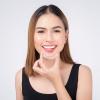 Smiling woman holding invisalign braces
