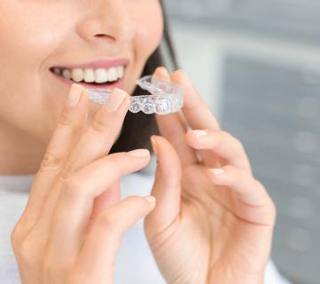 girl holding zenyum clear aligners