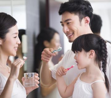 happy family brushing teeth in the bathroom