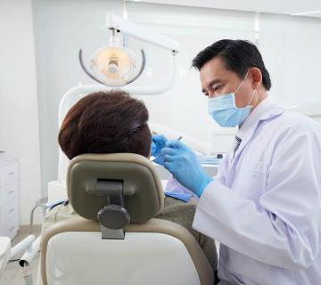 male dentist treating patient with tooth decay Singapore