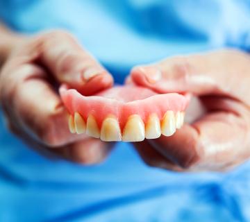 woman holding overdentures
