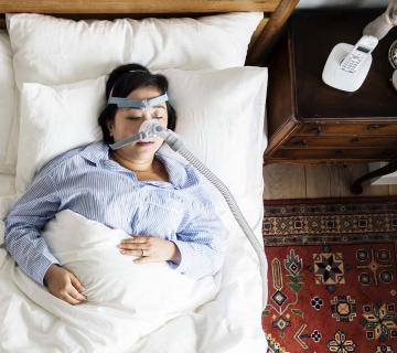 woman sleeping with anti snoring mask for sleep apnea