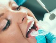 woman at a dentist for a teeth whitening procedure woman at a dentist for a teeth whitening procedure